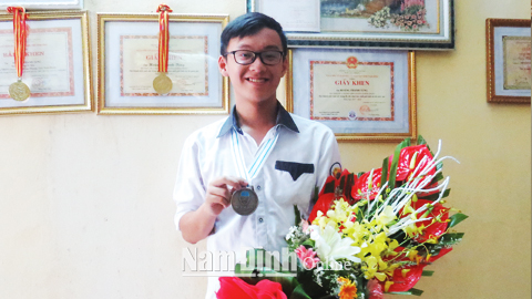 Hoàng Thanh Tùng với tấm Huy chương Bạc Ô-lim-pích Hóa học quốc tế.