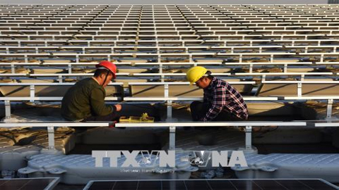 Công nhân làm việc tại Nhà máy điện Mặt trời ở Hoài Nam, tỉnh An Huy, miền đông Trung Quốc tháng 12/2017. Ảnh: AFP/ TTXVN