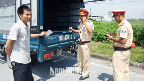 Cán bộ Phòng Cảnh sát giao thông đường bộ - đường sắt (Công an tỉnh) kiểm tra, xử lý xe quá tải tại địa phận huyện Vụ Bản.