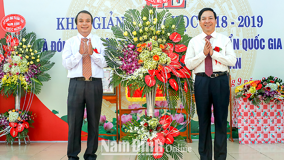 Đồng chí Trần Văn Chung, Phó Bí thư Thường trực Tỉnh ủy, Chủ tịch HĐND tỉnh tặng giáo viên, học sinh Trường THCS Yên Bình (Ý Yên) lẵng hoa tươi thắm
