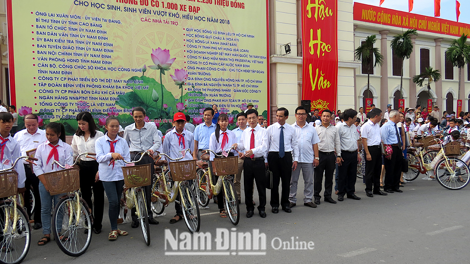 Đồng chí Phạm Đình Nghị, Phó Bí thư Tỉnh ủy, Chủ tịch UBND tỉnh trao tặng học bổng bằng xe đạp cho học sinh nghèo vượt khó hiếu học.