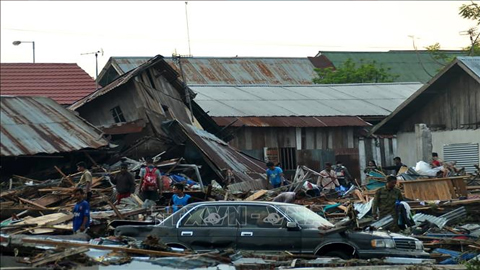Nhà cửa và phương tiện bị tàn phá nghiêm trọng sau các trận động đất và sóng thần tại tỉnh Trung Sulawesi, Indonesia ngày 29/9/2018. Ảnh: AFP/TTXVN