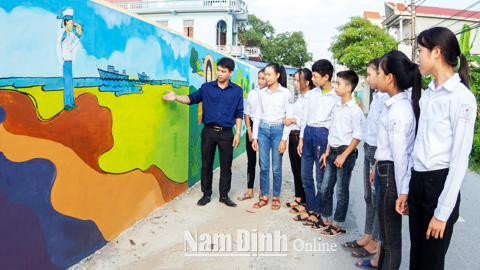 Thầy và trò Trường THCS Quang Trung trong buổi học ngoại khóa về thông điệp từ các bức tranh tường.