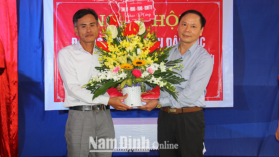 Đồng chí Nguyễn Viết Hưng, Ủy viên Ban TVTU, Phó Chủ tịch Thường trực HĐND tỉnh tặng hoa, chúc mừng cấp ủy, chính quyền và nhân dân khu dân cư Trại Nội.