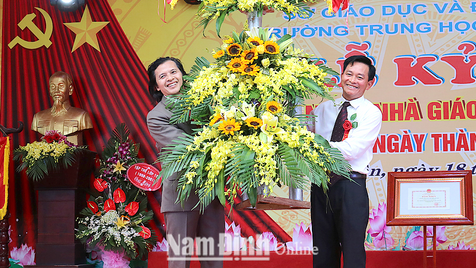 Đồng chí Nguyễn Phùng Hoan, TUV, Phó Chủ tịch UBND tặng lẵng hoa tươi thắm cho tập thể cán bộ, giáo viên, học sinh Trường THPT Mỹ Tho (Ý Yên).