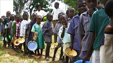 Trẻ em xếp hàng đợi nhận khẩu phần ăn do Chương trình Lương thực Thế giới tài trợ tại Harare, Zimbabwe.  Ảnh: AFP/TTXVN