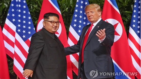 Nhà lãnh đạo Triều Tiên Kim Jong-un (bên trái) và Tổng thống Mỹ Donald Trump tại cuộc gặp thượng đỉnh đầu tiên ở Singapore, ngày 12-6-2018. (Ảnh: Yonhap)