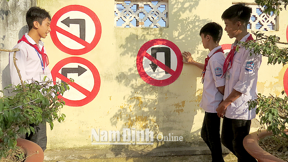 Các em học sinh Trường Trung học cơ sở Yên Ninh (Ý Yên) tìm hiểu các tín hiệu biển báo giao thông.