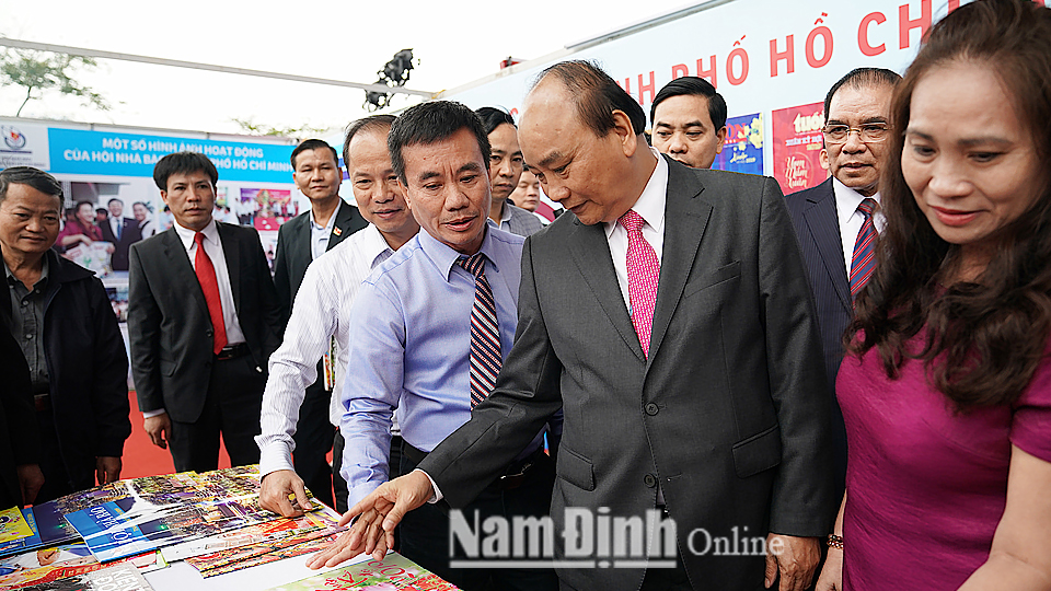 Thủ tướng Nguyễn Xuân Phúc, nguyên Tổng Bí thư Nông Đức Mạnh thăm các gian trưng bày tại Hội Báo toàn quốc năm 2019. Ảnh: VGP/Quang Hiếu