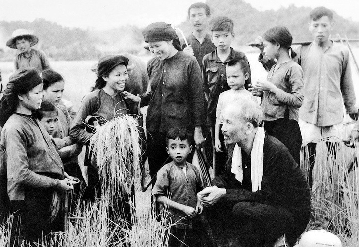 Chủ tịch Hồ Chí Minh thăm hỏi nông dân Hợp tác xã Hùng Sơn (huyện Đại Từ, tỉnh Thái Nguyên) đang gặt lúa, năm 1954. Ảnh: Tư liệu