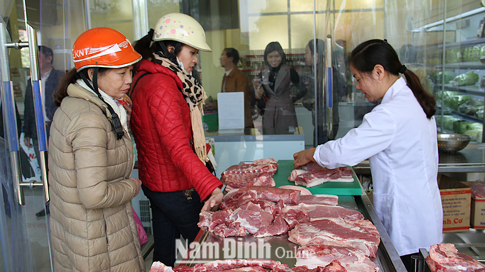 Người tiêu dùng lựa chọn sản phẩm thịt lợn an toàn tại cửa hàng giới thiệu sản phẩm Hiệp hội Nông sản sạch Nam Định.