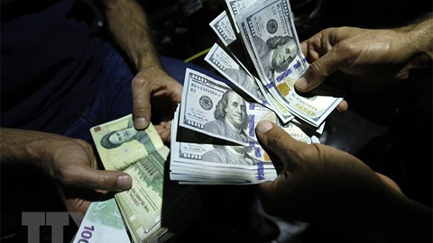 Giao dịch đổi đồng Rials của Iran và đồng đôla Mỹ tại một cửa hàng ngoại hối ở thủ đô Tehran, Iran. (Ảnh: AFP/TTXVN)