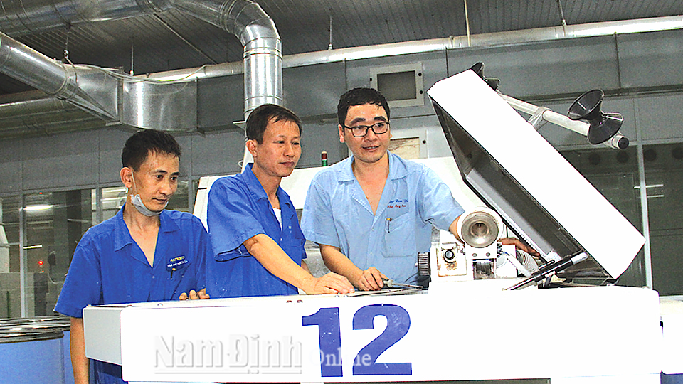 Công nhân tổ cơ điện Nhà máy Sợi Vinatex Nam Định nghiên cứu cải tiến thiết bị tiết kiệm điện.