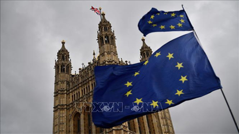 Cờ Liên minh châu Âu (bên phải) và quốc kỳ Anh (trái) bên ngoài tòa nhà Quốc hội Anh ở London. Ảnh: AFP/TTXVN