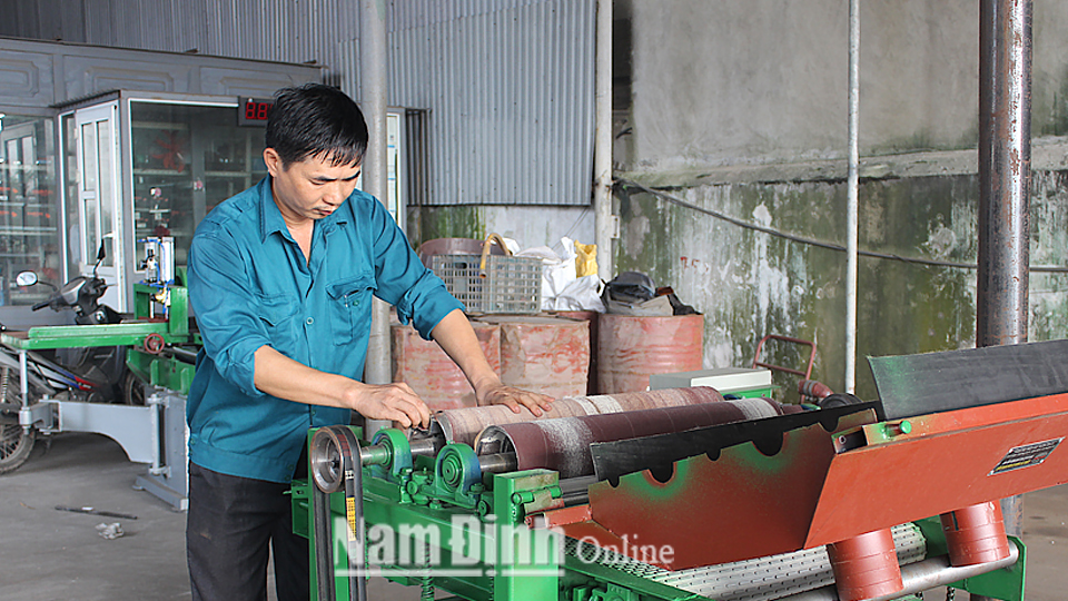 Anh Bùi Quang Huân, Công ty Trách nhiệm hữu hạn Cơ khí Đình Mộc, xã Xuân Kiên (Xuân Trường) bên chiếc máy trà nhám mang lại hiệu quả cao trong sản xuất.