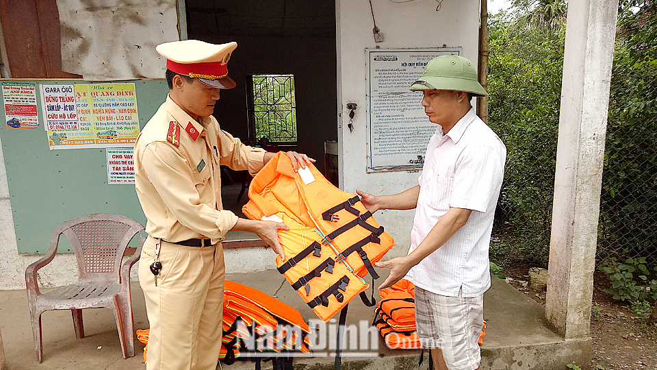 Lực lượng Cảnh sát Giao thông (Công an tỉnh) tặng áo phao cho người dân.