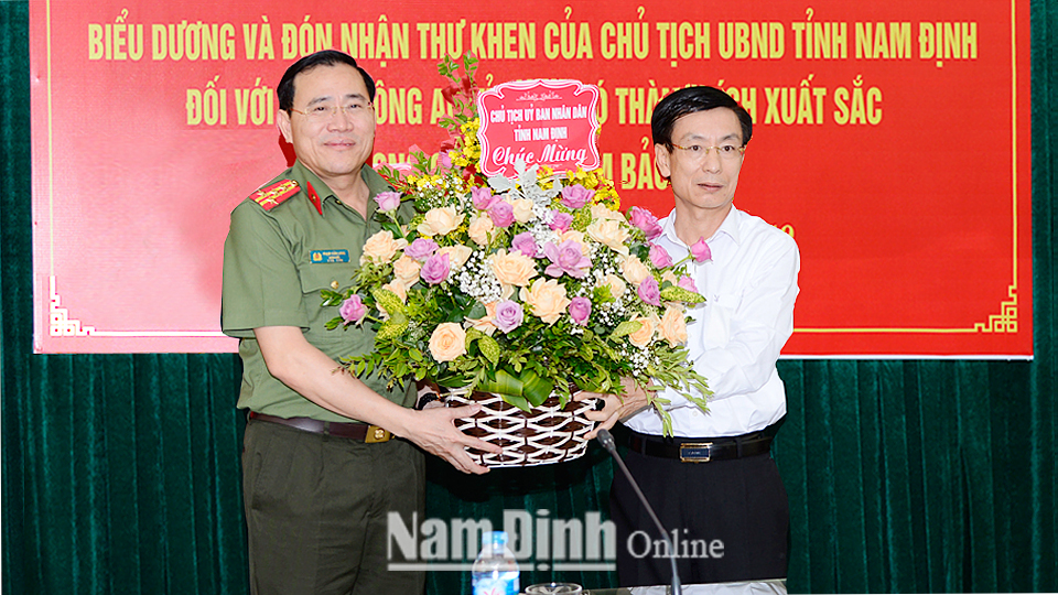 Đồng chí Phạm Đình Nghị, Phó Bí thư Tỉnh ủy, Chủ tịch UBND tỉnh tặng hoa chúc mừng thành tích xuất sắc của lực lượng Công an tỉnh.