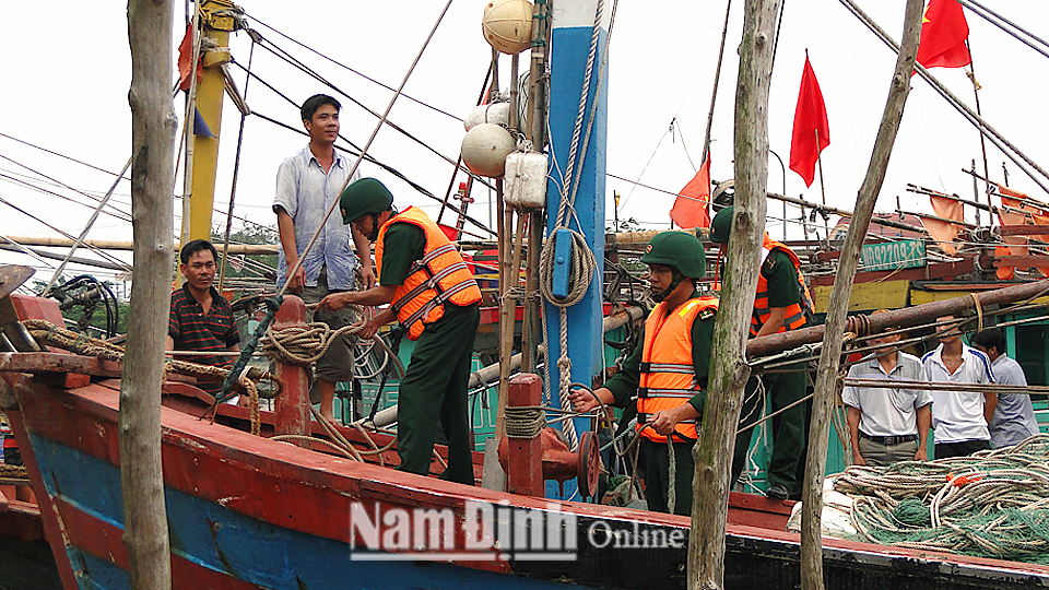 Cán bộ, chiến sĩ Bộ Chỉ huy Bộ đội Biên phòng tỉnh giúp ngư dân neo đậu tàu thuyền phòng, chống lụt bão.