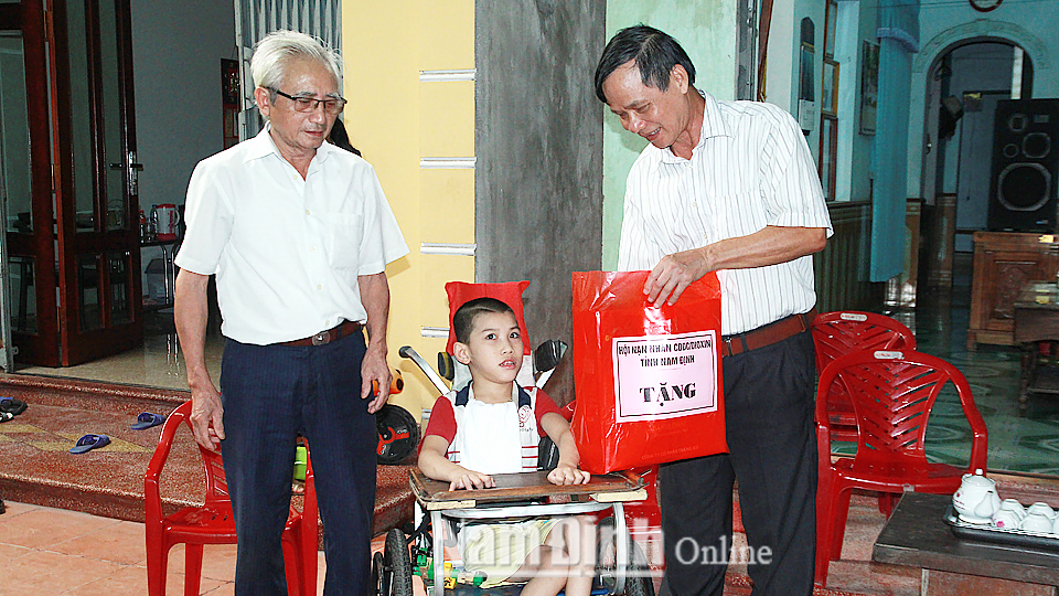 Hội Nạn nhân chất độc da cam/đi-ô-xin tỉnh trao tặng quà cho cháu Trần Đức Chính ở đường Giải Phóng, phường Trường Thi (Thành phố Nam Định).