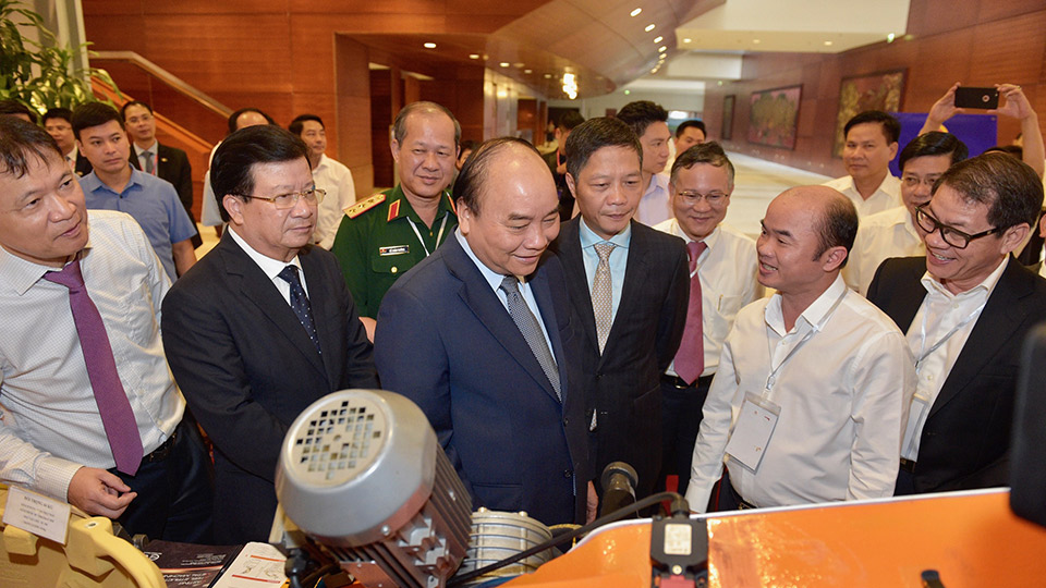 Thủ tướng Nguyễn Xuân Phúc, Phó Thủ tướng Trịnh Đình Dũng thăm các gian trưng bày sản phẩm cơ khí tại hội nghị.  Ảnh: VGP/Nhật Bắc