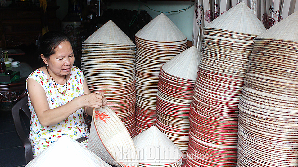 Chị Phạm Thị Hồng xóm 14, xã Nghĩa Châu (Nghĩa Hưng) hoàn thiện sản phẩm nón trước khi xuất bán.