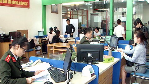Cán bộ Phòng QLXNC (Công an tỉnh) hướng dẫn công dân làm thủ tục XNC. Ảnh: baoquangninh.com.vn