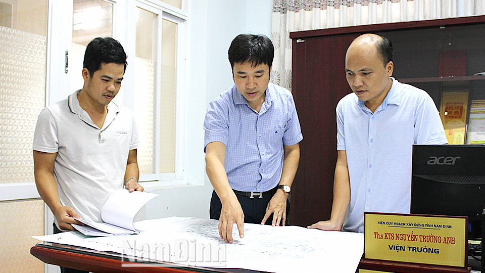 Cán bộ Viện Quy hoạch xây dựng tỉnh Nam Định (Sở Xây dựng) nghiên cứu bản vẽ sơ đồ tổ chức không gian kiến trúc cảnh quan Khu công nghiệp Mỹ Thuận.