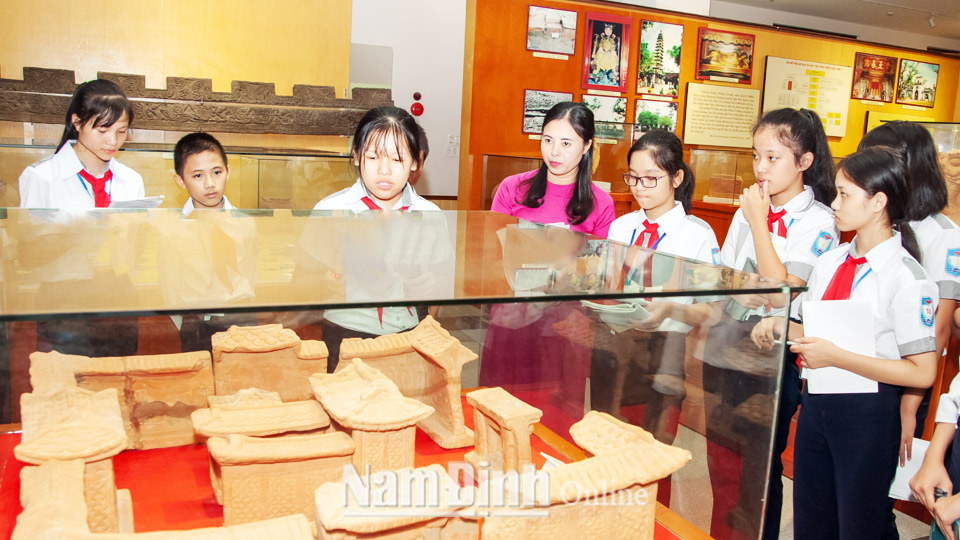 Học sinh tham quan, tìm hiểu Bảo vật quốc gia Mô hình nhà thời Trần được lưu giữ ở Bảo tàng tỉnh.