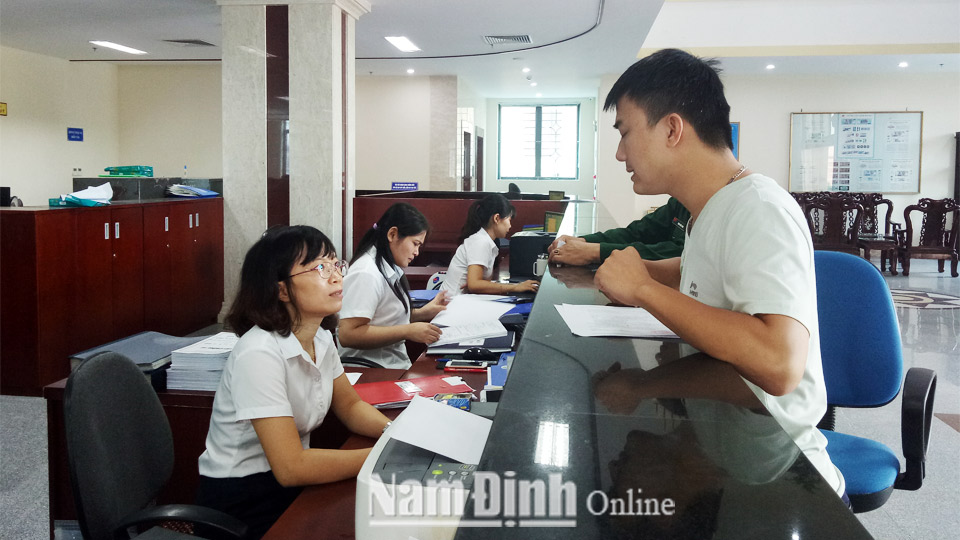 Cán bộ Kho bạc Nhà nước Nam Định hướng dẫn người dân hoàn tất thủ tục hành chính.