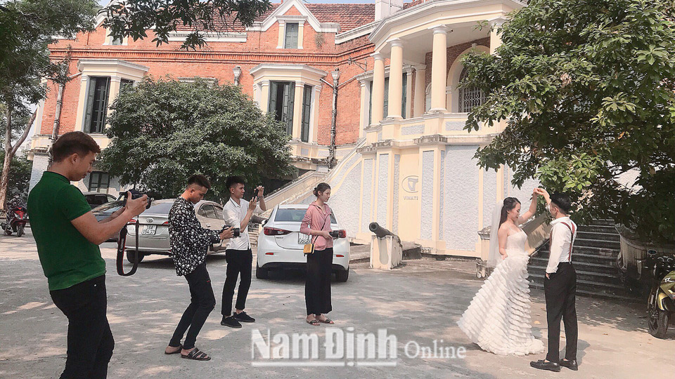 Anh Phạm Văn Tuyên (ngoài cùng bên trái) cùng đội ngũ nhân viên của cửa hàng áo cưới luôn say sưa với công việc.