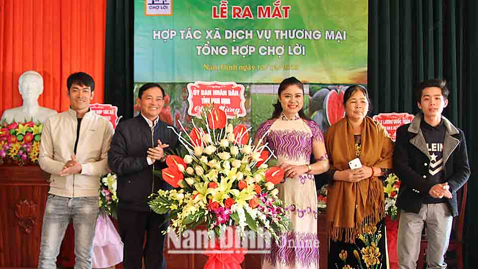 Đồng chí Nguyễn Phùng Hoan, Tỉnh ủy viên, Phó Chủ tịch UBND tỉnh tặng hoa chúc mừng Hợp tác xã dịch vụ thương mại tổng hợp chợ Lời.