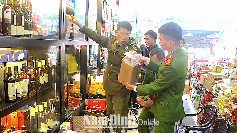Lực lượng Quản lý thị trường phối hợp với lực lượng Công an thành phố Nam Định kiểm tra sản phẩm rượu nhập khẩu lưu thông trên thị trường.