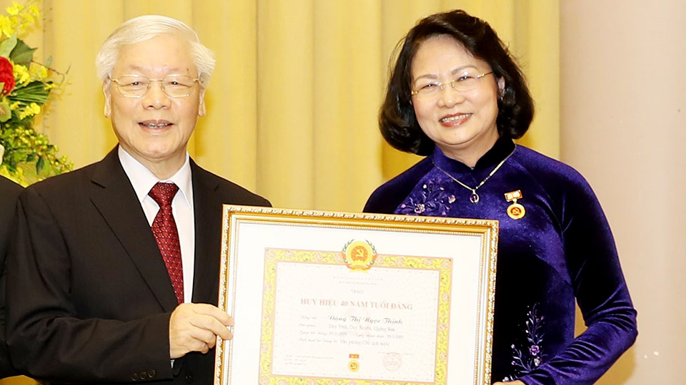 Tổng Bí thư, Chủ tịch nước Nguyễn Phú Trọng trao Huy hiệu 40 năm tuổi Đảng tặng đồng chí Đặng Thị Ngọc Thịnh.  Ảnh: Trí Dũng - TTXVN