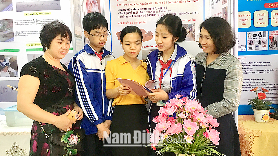 Cô và trò Trường THCS Lương Thế Vinh (thành phố Nam Định) trao đổi về sản phẩm STEM “Bàn - ghế ngồi đa năng” tham gia Ngày hội.