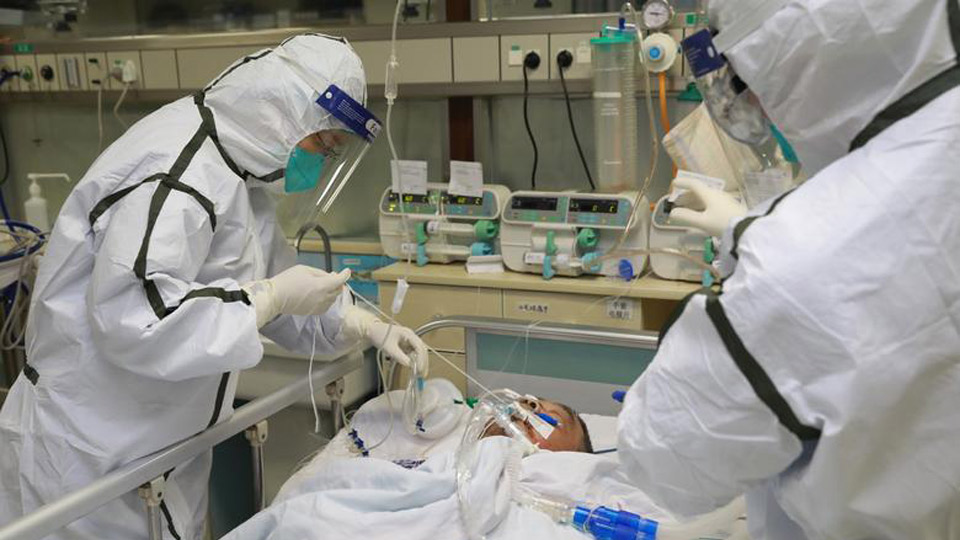 Bác sĩ mặc đồ bảo hộ điều trị cho bệnh nhân nhiễm virus Corona chủng mới tại Vũ Hán.  Ảnh: Reuters