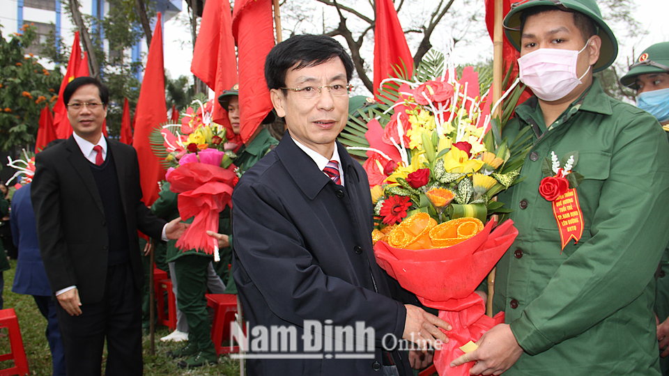 Ðồng chí Phạm Ðình Nghị, Phó Bí thư Tỉnh ủy, Chủ tịch UBND tỉnh tặng hoa, động viên tân binh thành phố Nam Ðịnh lên đường nhập ngũ 