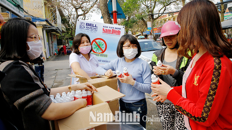 Cán bộ, phóng viên Báo Nam Định phát nước rửa tay khô diệt khuẩn cho người dân phòng, chống dịch COVID-19 tại Bệnh viện Nhi tỉnh.