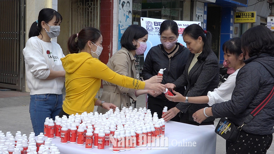 Cán bộ, phóng viên Báo Nam Định phát nước rửa tay khô diệt khuẩn cho người dân phòng, chống dịch COVID-19 tại trụ sở Báo Nam Định.