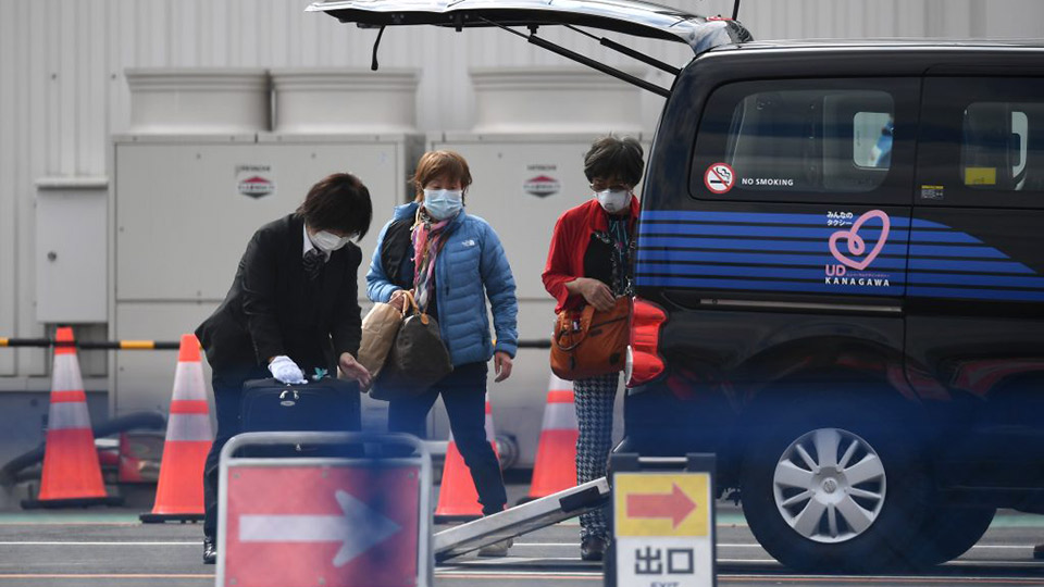 Hành khách sơ tán khỏi du thuyền Diamond Princess tại cảng Yokohama, Nhật Bản ngày 19-2-2020, sau khi có xét nghiệm âm tính với COVID-19.  Ảnh: AFP/TTXVN