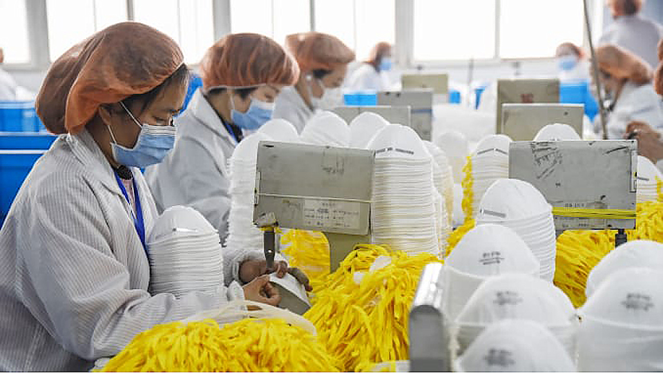 Các công nhân làm việc trong nhà máy sản xuất khẩu trang tại Trung Quốc. Ảnh: Reuters