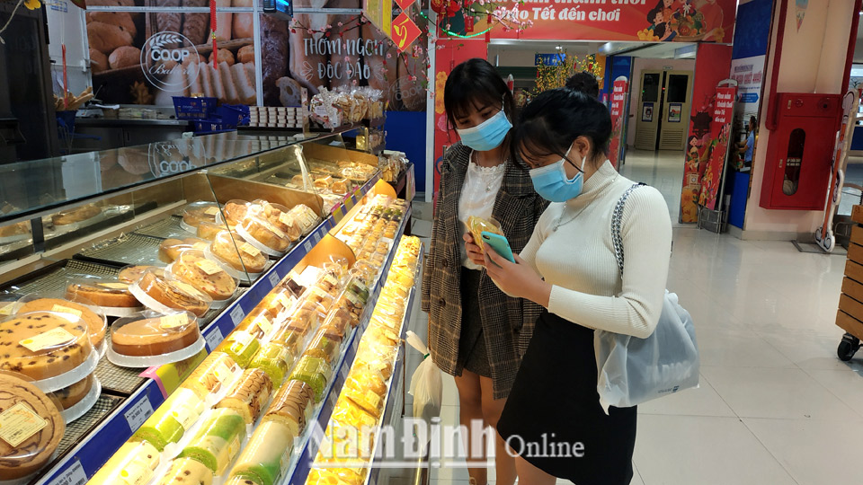 Người tiêu dùng nghiêm túc tuân thủ việc đeo khẩu trang phòng bệnh khi mua sắm tại siêu thị Co.opmart (thành phố Nam Định).