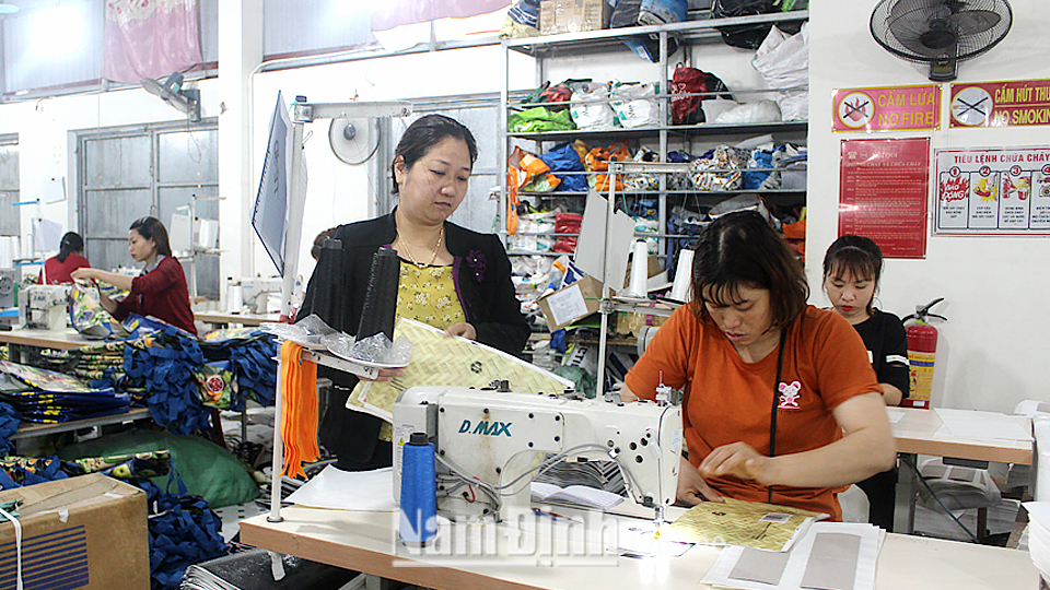 Chị Phạm Thị Vui, xóm 8 Hải Toàn, xã Hải An, huyện Hải Hậu (người đứng bên trái) kiểm tra quy trình sản xuất tại xưởng.