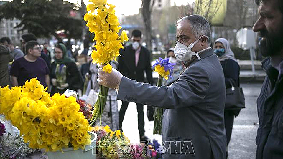 Người dân đeo khẩu trang để phòng tránh lây nhiễm COVID-19 tại Tehran, Iran, ngày 19/3/2020. Ảnh: THX/TTXVN
