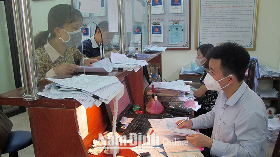 Cán bộ Trung tâm hành chính một cửa huyện Hải Hậu hỗ trợ người dân giải quyết thủ tục hành chính.