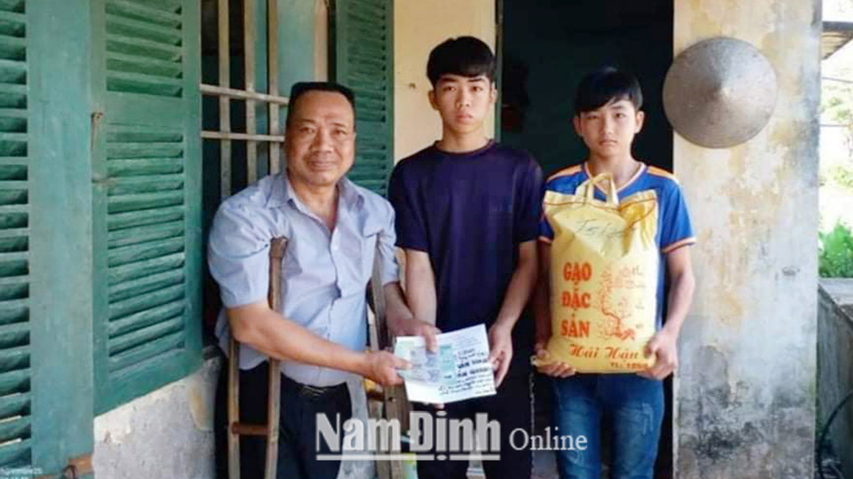 Anh Nguyễn Ngọc Sơn đại diện cho các nhóm thiện nguyện trao tiền và gạo cho hai học sinh mồ côi ở xã Minh Thuận (Vụ Bản).