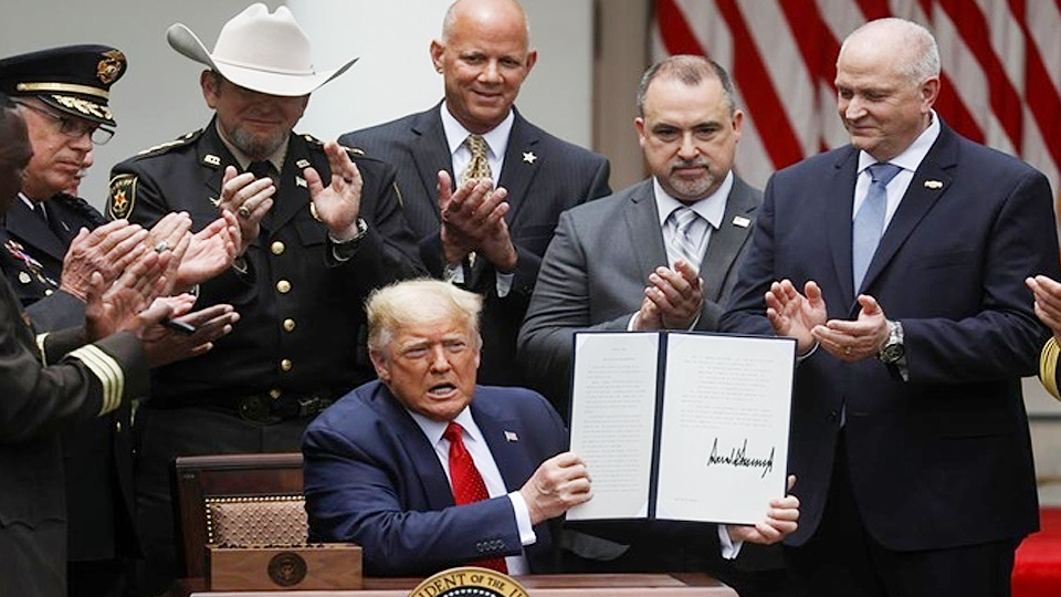 Tổng thống Trump ký sắc lệnh tại Vườn Hồng, Nhà Trắng, ngày 16-6. (Ảnh: Reuters).
