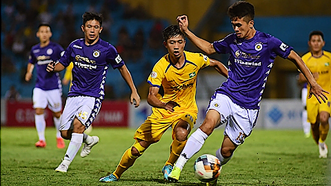  Pha tranh bóng giữa cầu thủ đội Hà Nội FC (áo tím) và đội Sông Lam Nghệ An. Ảnh: ÐỨC ANH