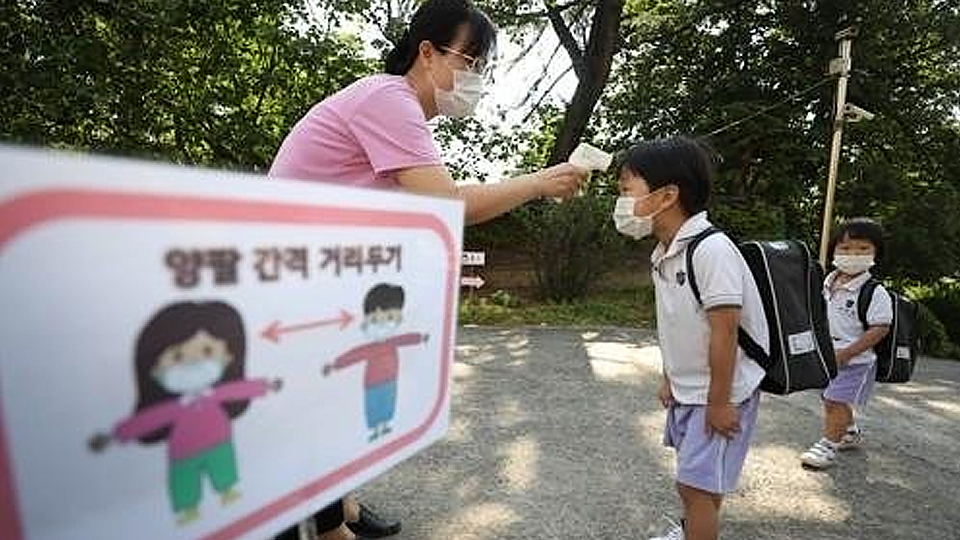 Giáo viên kiểm tra nhiệt độ cho các em học sinh tại Daegu (Ảnh: YONHAP)