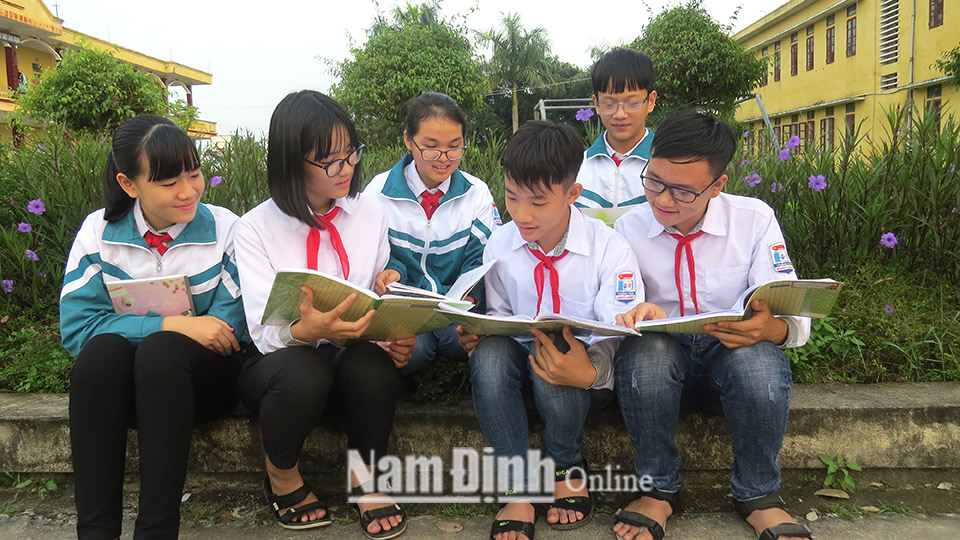 Các em học sinh nghèo vượt khó ở Trường THCS Nghĩa Hưng trao đổi bài trước giờ học.
