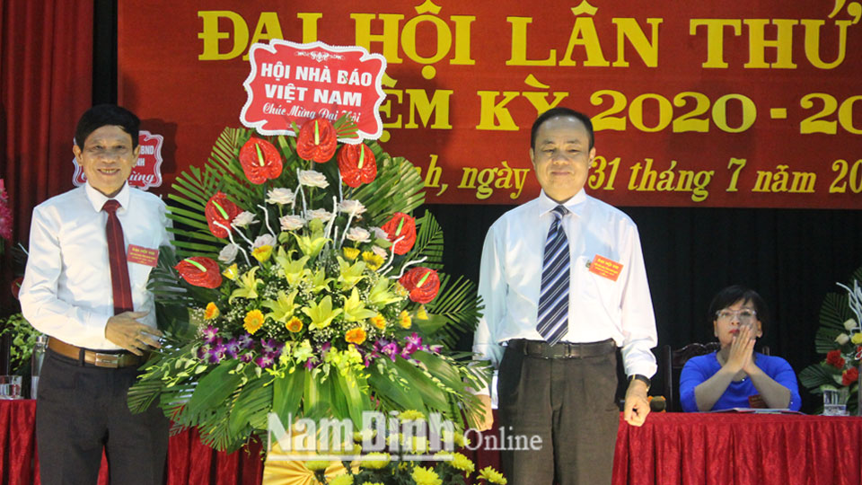 đồng chí Trần Bá Dung, Uỷ viên Ban thường vụ, trưởng ban nghiệp vụ Hội Nhà báo Việt Nam trao tặng đại hội lẵng hoa tươi thắm